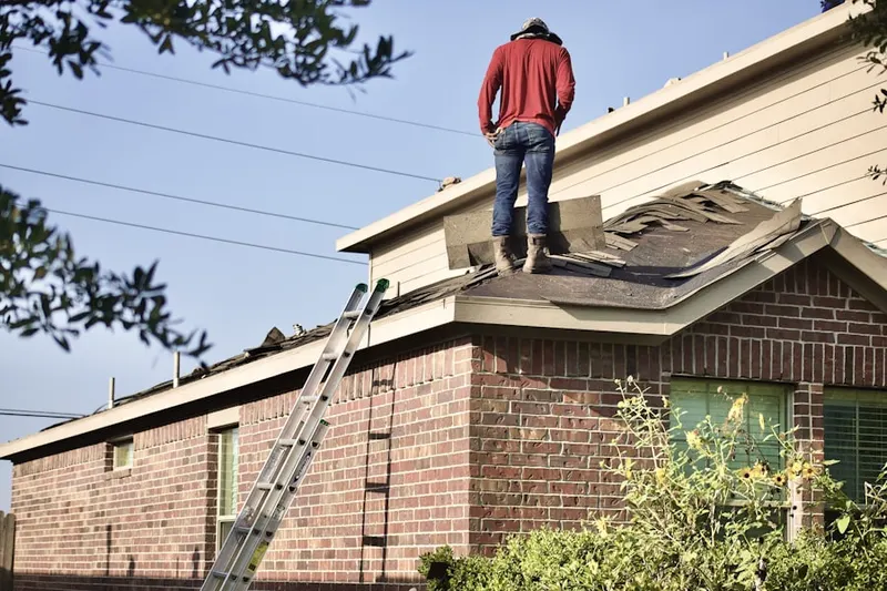 Professional roofer working on a residential roof in Ambrose